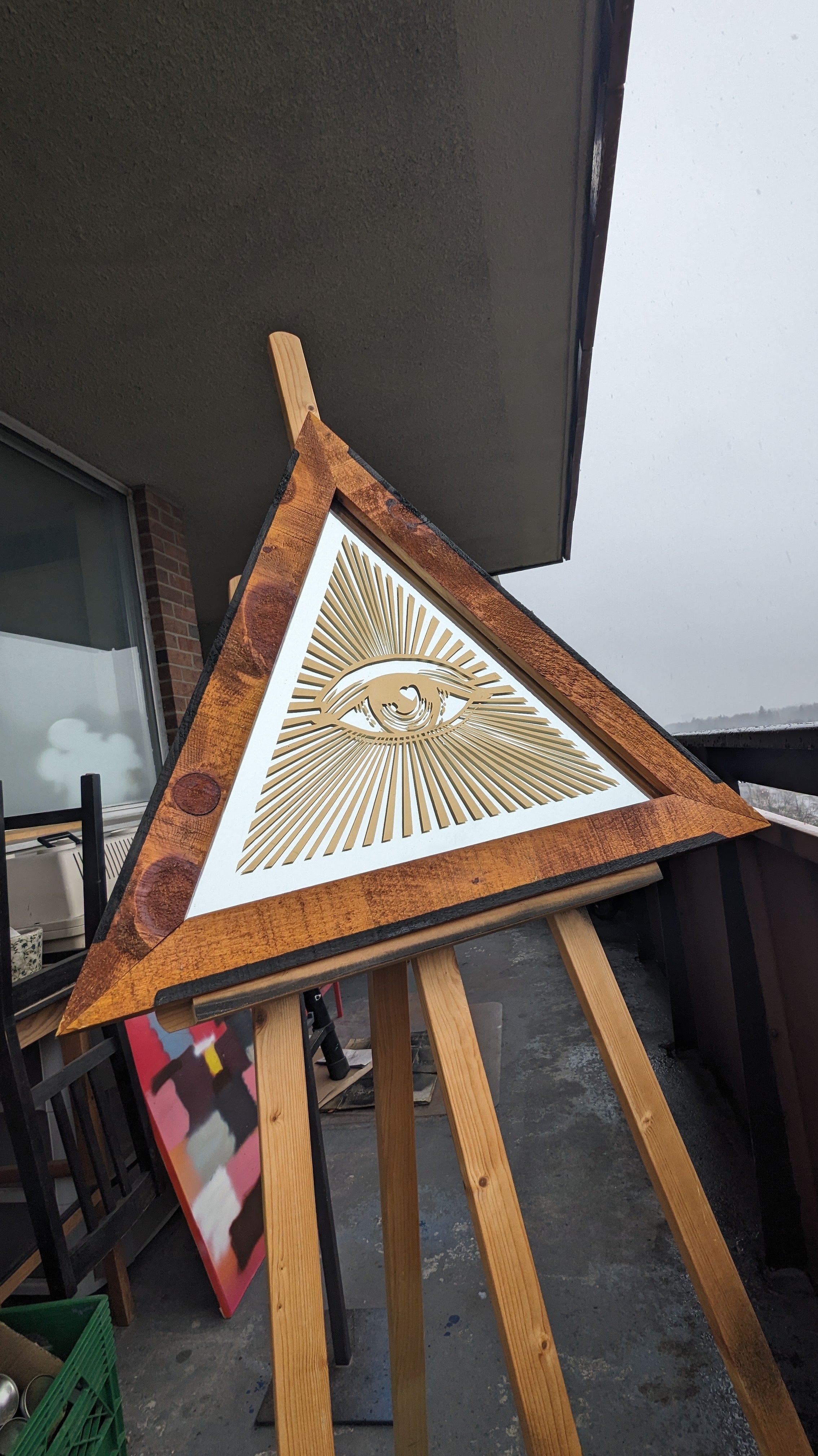 Wooden framed triangular mirror with spray painted design. 24’ wide at base, 20’ tall at centre 